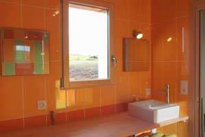 Salle de bain : vasque, miroir, petite fenêtre sur jardin